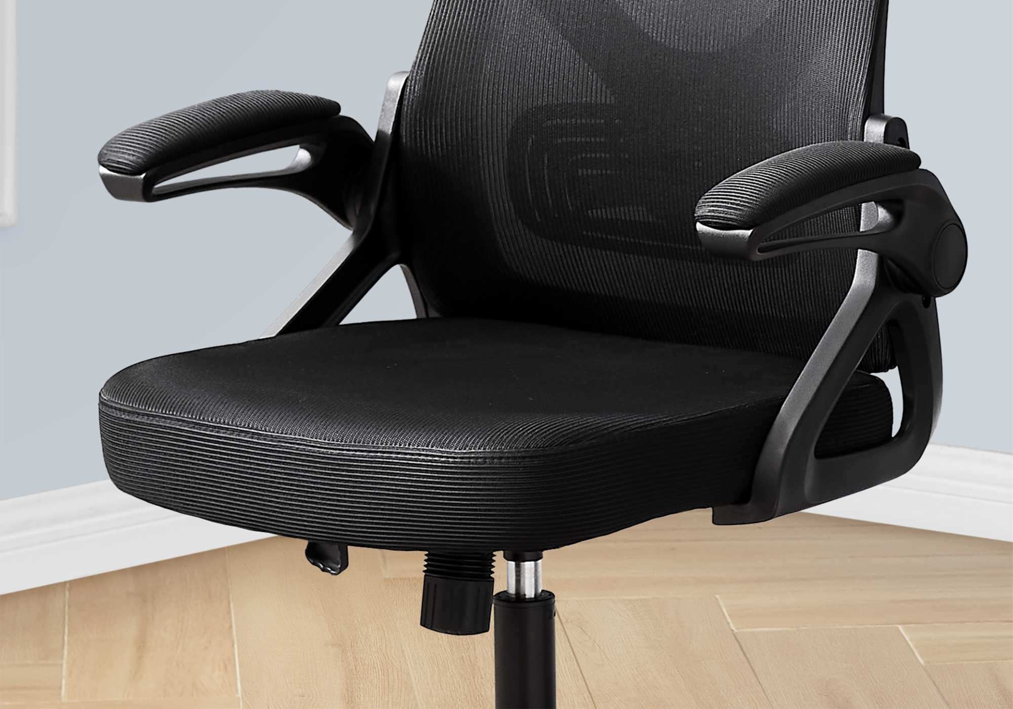Black mesh office chair placed at a modern work desk setup, showing breathable back and smooth wheels