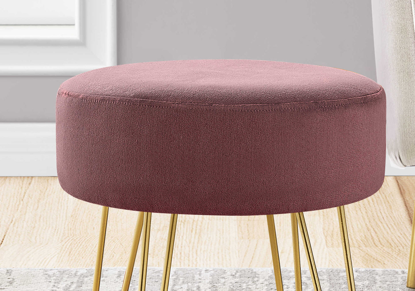 Soft pink round ottoman styled with neutral furniture in modern boho living room